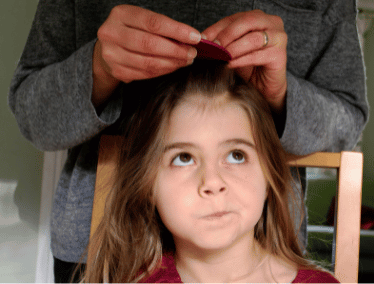 mother checking child for nits and headlice